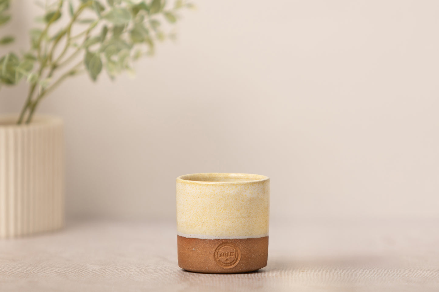 aromatherapy candle with a ceramic handmade pot on a beige fabric background